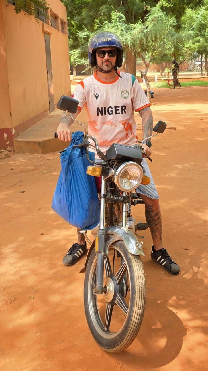 Kamil w koszulce Niger na motocyklu